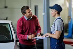 happy-man-talking-female-mechanic-while-signing-paperwork-auto-repair-shop_637285-7762